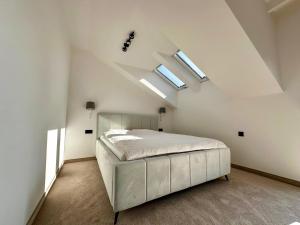JasionkaVerde Klon Apartment- Lotnisko Jasionka的白色卧室配有一张床和天窗