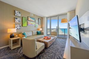 ein Wohnzimmer mit Sofa und Tisch in der Unterkunft Luxury 2BR Beachfront Rooftop Pool and Spa in Hollywood