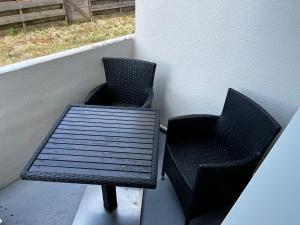 two chairs and a table on a porch at Appartement cocon in La Teste-de-Buch
