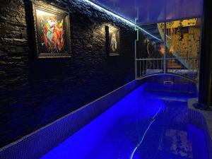 a swimming pool with blue lights in a room at Love Room -La Suite Secrète in Rodez
