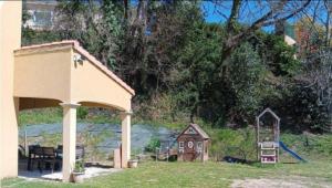 a playground with a small house and a slide at La Flaviacoise s'agrandie in Flaviac