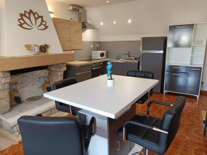 a kitchen with a white table and black chairs at Escale Détente-Loft avec Terrasse- Parking Montargis in Montargis