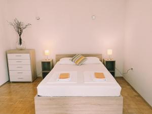 a bedroom with a bed with two night stands and two lamps at Active Apartments Koper in Koper