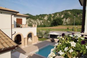 a view of a house with a swimming pool and flowers at Residence Stella Del Gran Sasso in Colledara
