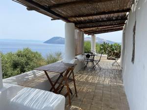 a porch with a table and a view of the ocean at Traditional Eolian House Luna - Unique experience in San Salvatore