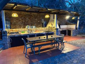 a table and chairs sitting in front of a kitchen at Traditional Eolian House Luna - Unique experience in San Salvatore