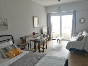 ein Schlafzimmer mit Bett und ein Wohnzimmer in der Unterkunft Asterias blue Studio in Ermioni