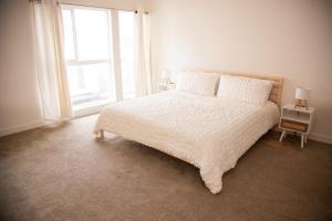 Un dormitorio con una cama blanca con una ventana. en Your Home Away from Home, en Corona