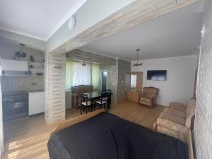 a living room with a table and a kitchen at Apartament pushim pogradec in Pogradec