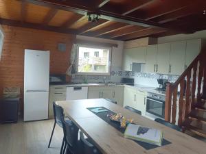 kuchnia z drewnianym stołem i białą lodówką w obiekcie Chalet idéal 4-8 pers avec garage 20 mn Gérardmer w mieście Vienville