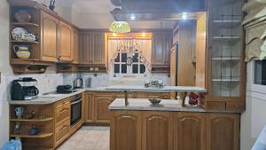 a kitchen with wooden cabinets and a counter top at Magical Dawn from Leonidio to Tyros in Péra Mélana
