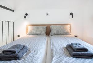 a bedroom with a bed with two towels on it at Black Emerald - Vrdnik in Vrdnik