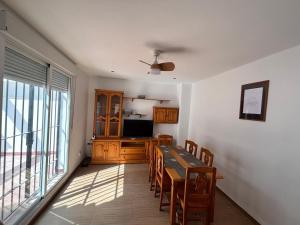 Un comedor con mesa y sillas y un televisor. en Apartamento Mar de Castell, en Castell de Ferro