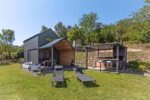 a small house with chairs and a grill in a yard at Black Emerald - Vrdnik in Vrdnik