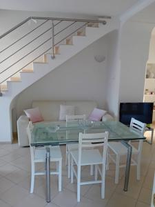 a dining room with a glass table and white chairs at L'Albero della vita in Piano di Sorrento +19 photos