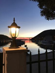 a light on a wall near a body of water at KiM in Mokošica
