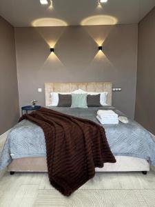 a bedroom with a large bed with a blanket on it at Квартира с видом на Усть-Каменогорск in Ustʼ-Kamenogorsk