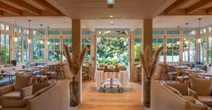 a dining room with tables and chairs and windows at La Villa du Moulleau in Arcachon