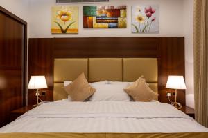 a bedroom with a large bed with two lamps at Rosalina Hotel in Yanbu