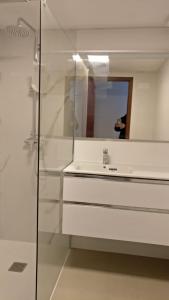 a white bathroom with a sink and a mirror at T2 Praia in Póvoa de Varzim