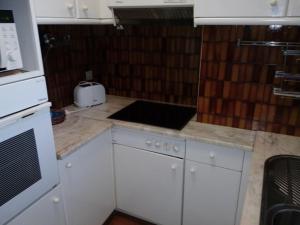 a kitchen with white cabinets and a counter top at T2 Praia in Póvoa de Varzim