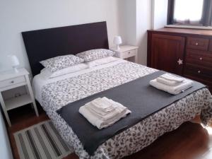 a bedroom with a large bed with towels on it at T2 Praia in Póvoa de Varzim