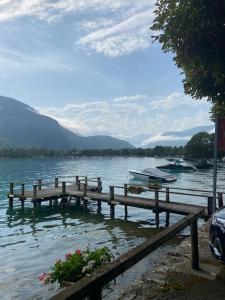 a dock on a lake with a boat in the water at Maisonnette in Lathuile