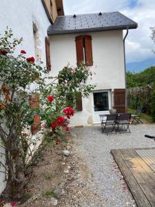 a white building with a bench and flowers in front of it at Maisonnette in Lathuile