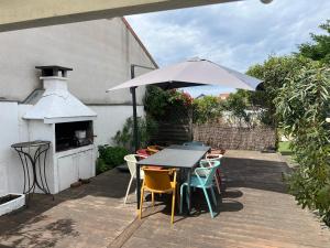a table and chairs with an umbrella on a patio at MAMALO in Biscarrosse