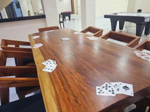 a wooden table with playing cards on top of it at Villa Luxury Cissne -Vive el encanto en la Riviera Maya in Xetna
