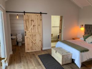 a bedroom with a bed and a sliding barn door at Sea and Mountain View in Mossel Bay
