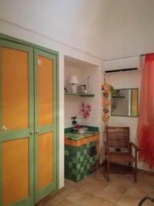 Habitación con cocina con mesa y silla. en Dammuso Specchio di Vener, en Pantelleria