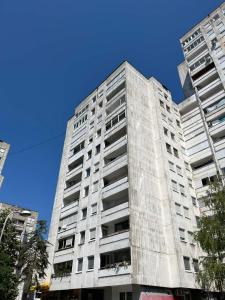 a tall white building with a blue sky behind it at Alex Bl in Banja Luka