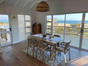 a dining room with a wooden table and chairs at Sea and Mountain View in Mossel Bay