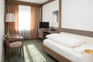 ヴァルツフート・ティンゲンにあるHotel & Restaurant Waldshuter Hofのベッドと机とパソコンが置かれたホテルの部屋