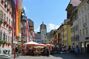 ヴァルツフート・ティンゲンにあるHotel & Restaurant Waldshuter Hofの時計塔を持つ道を歩く人々
