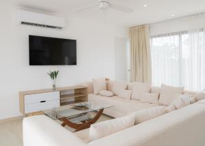 Una sala de estar blanca con un sofá blanco y una mesa. en Penthouse Blue Luxury Kukulkan, en Tulum 13 fotos más