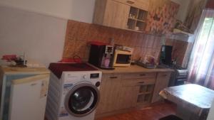 a kitchen with a washing machine and a microwave at Apartament Ștefania in Orşova +3 photos