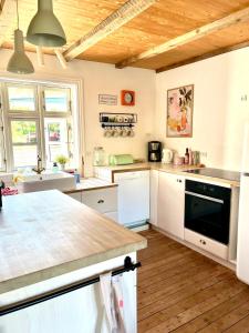 a kitchen with white cabinets and a wooden ceiling at Cozy Holiday Home in Sandavágur +24 photos
