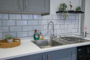 eine Küchentheke mit einem Waschbecken und einem Waschbecken in der Unterkunft The Tenstay -Stylish 5BR Home Close To All in Ifield + 44 Fotos
