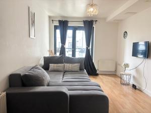 a living room with a couch and a tv at Cosy 1-Bedroom Apartment in Central Grays with Parking & Excellent Transport Links in Stifford
