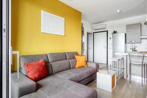 Una sala de estar con un sofá y una pared amarilla. en Ripamonti - Elegant Suite, en Milán
