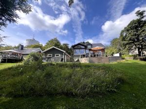 a house on top of a grassy hill at Stylish Villa, Terrace & Garden in Ljungby