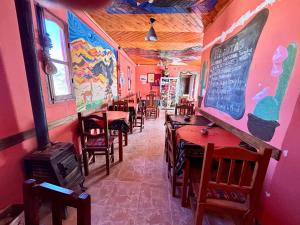a restaurant with tables and chairs and a menu on the wall at Hospedaje La Merced Humahuaca in Humahuaca