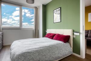 Un dormitorio con una cama con almohadas rojas y una ventana. en Ripamonti - Elegant Suite, en Milán