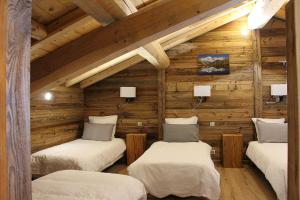 a room with three beds in a log cabin at Chambres et Tables d'Hôtes Le Choton à Nono - Col du Joly Beaufortain in Hauteluce