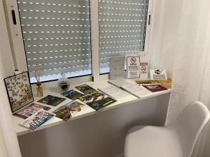 un tavolo con libri e riviste sul davanzale di una finestra di Casa da Covilhã - Pedra e Lã a Covilhã Altre 28 foto