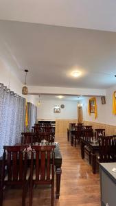 a dining room with wooden tables and chairs at Hotel Kaza Manjushree in Kaza