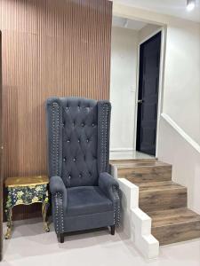 a blue chair in a room with a stairway at 2 bedroom cute log house in Bacolod- near NGC in Bacolod