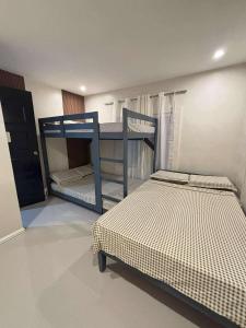 a bedroom with two bunk beds in a room at 2 bedroom cute log house in Bacolod- near NGC in Bacolod